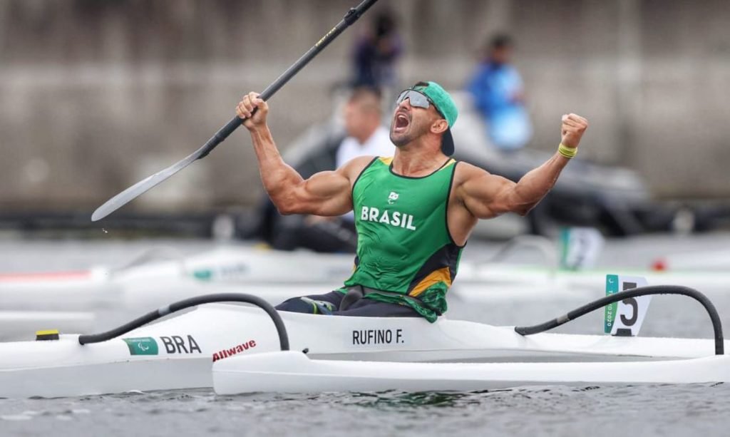 Descrição da imagem: Foto do atleta Fernando Rufino após a conquista da medalha de ouro. Ele está em seu caiaque, logo após a disputa. Fim da descrição.