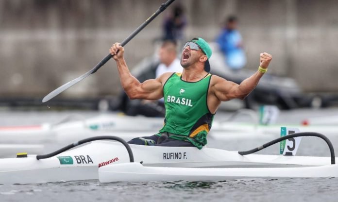 Descrição da imagem: Foto do atleta Fernando Rufino após a conquista da medalha de ouro. Ele está em seu caiaque, logo após a disputa. Fim da descrição.