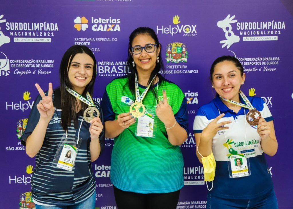 #descriçãodaimagem: foto das atletas Aline, Maria Carolina e Gisele, do xadrez. Fim da descrição.