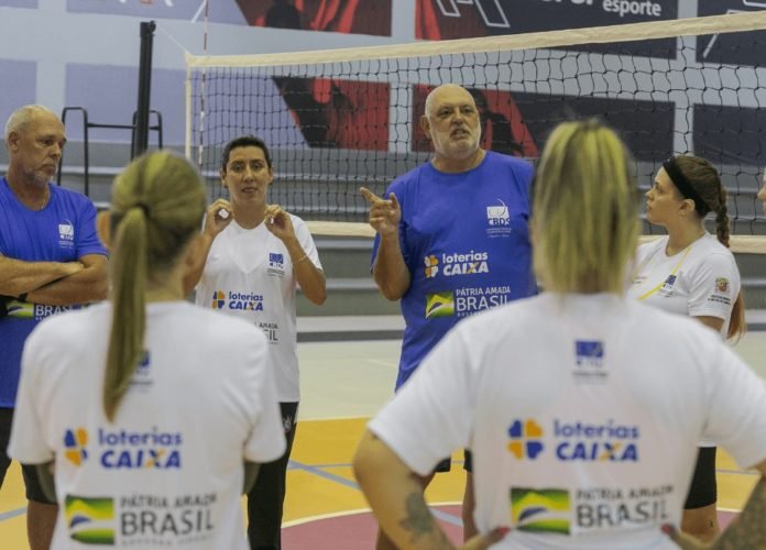 #descriçãodaimagem Foto do coordenador técnico Mário Xandó passando as orientações para as atletas durante o treino seletivo de voleibol da CBDS. Fim da descrição.