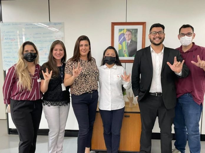 #descriçãodaimagem Foto de Diana e Larissa com membros da equipe do Ministério da Educação. Fim da descrição.