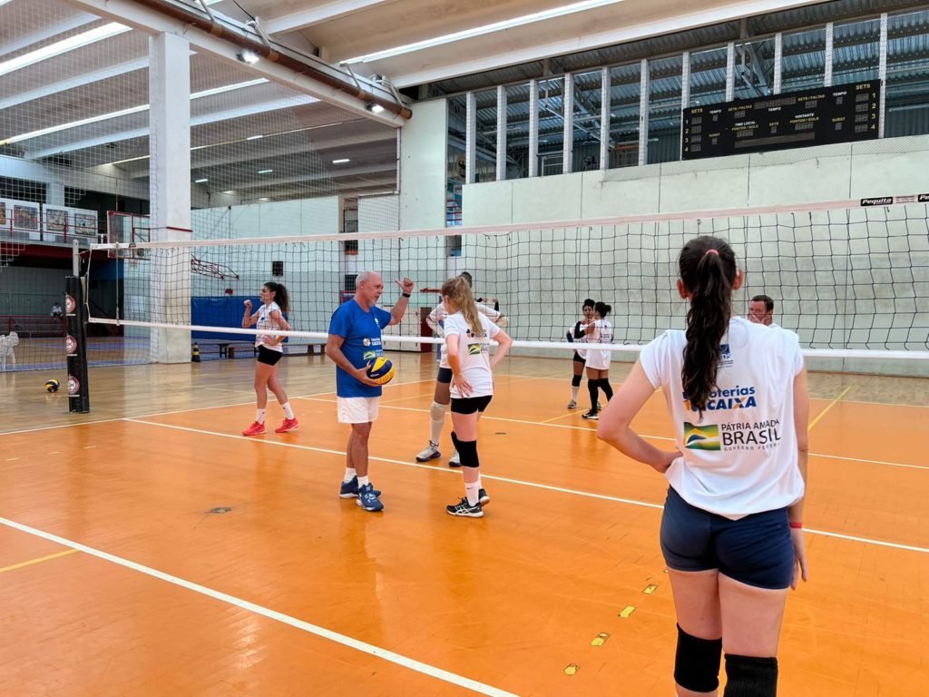 Descrição da imagem: Foto das atletas do vôlei na quadra durante treino. Fim da descrição.