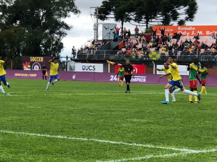Descrição da imagem: foto do momento do gol do Brasil na partida. Os jogadores brasileiros comemoram, enquanto o árbitro aponta para o meio do campo. Fim da descrição.