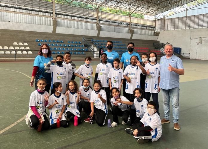 Descrição da imagem: foto dos alunos e da comissão técnica da escolinha de Futsal. Fim da descrição.