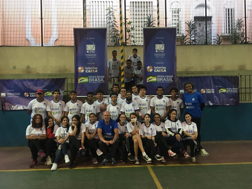 Descrição da imagem: foto dos alunos e da comissão técnica da escolinha de Vôlei. Fim da descrição.