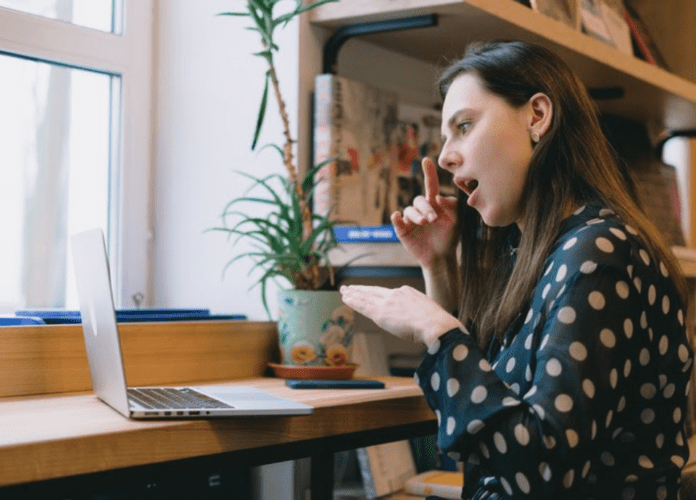 Descrição da imagem: foto de uma mulher surda se comunicando pelo computador. Fim da descrição.
