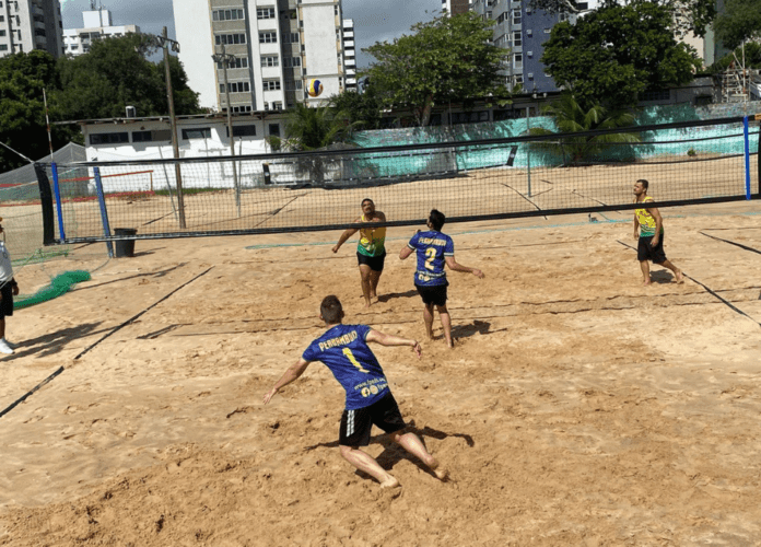 Descrição da imagem: foto de uma partida de vôlei de praia. Fim da descrição.