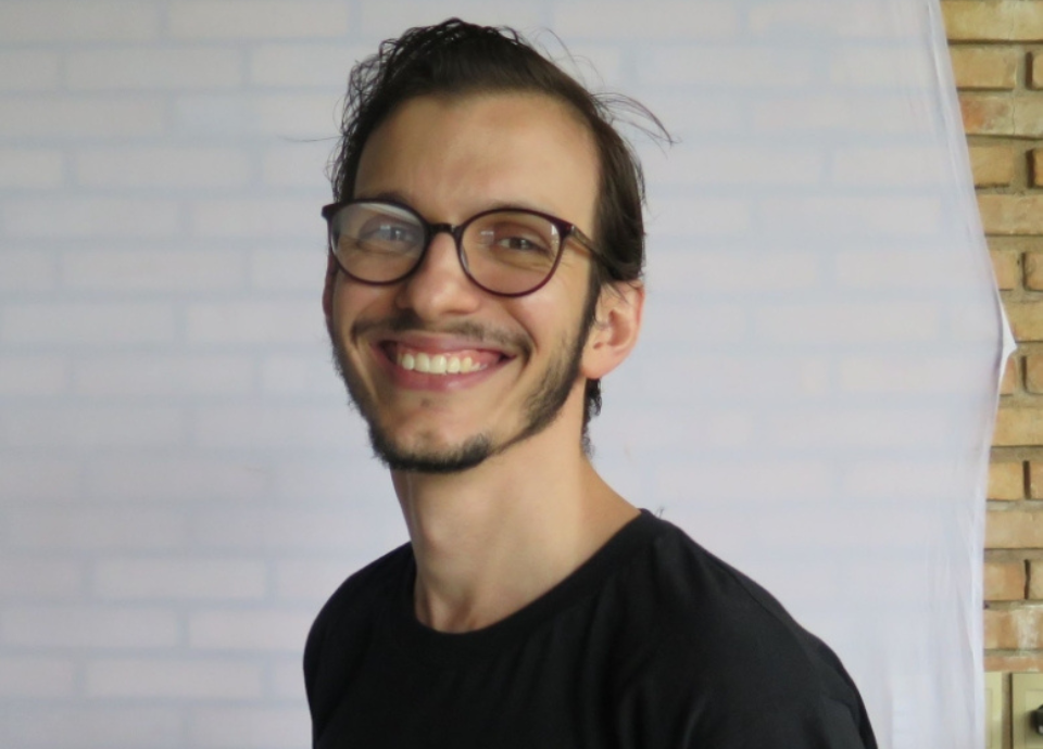Descrição da imagem: foto de João Bogas, diretor de Operações da Hand Talk. Ele é um homem jovem, branco, tem cabelos castanhos lisos e curtos. João está vestindo uma camiseta preta. Ele usa óculos e está sorrindo. Fim da descrição.