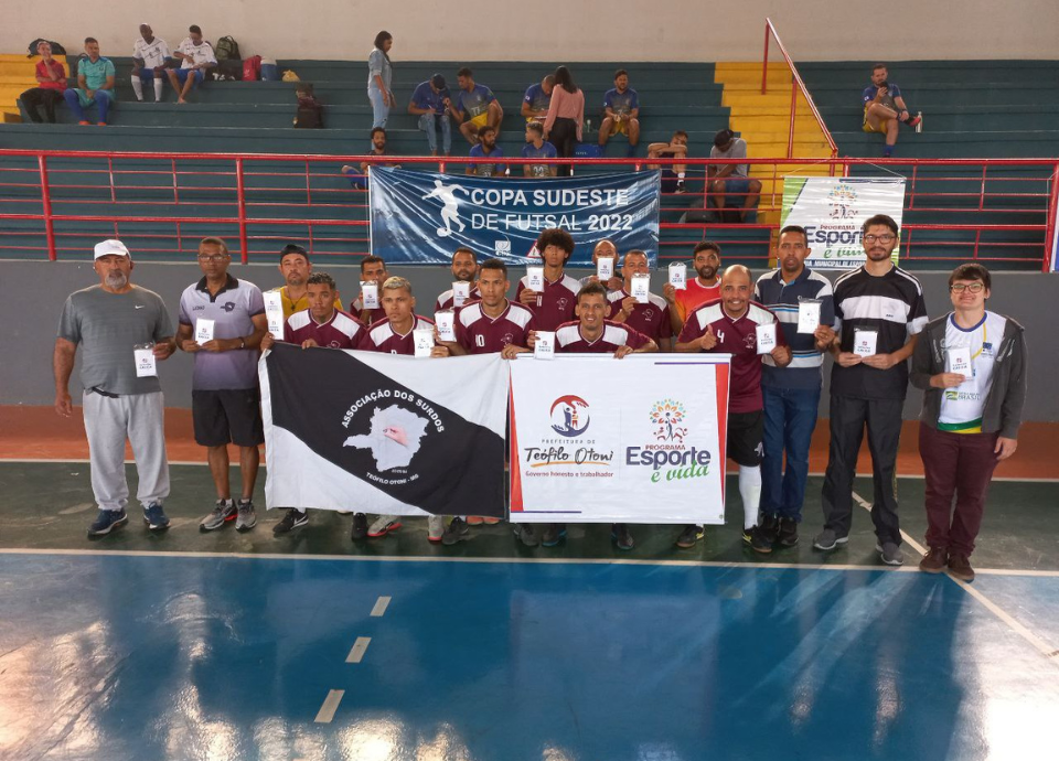 Descrição da imagem: foto dos surdoatletas da ASTO/MG. Eles estão perfilados e seguram a bandeira da associação. Fim da descrição.