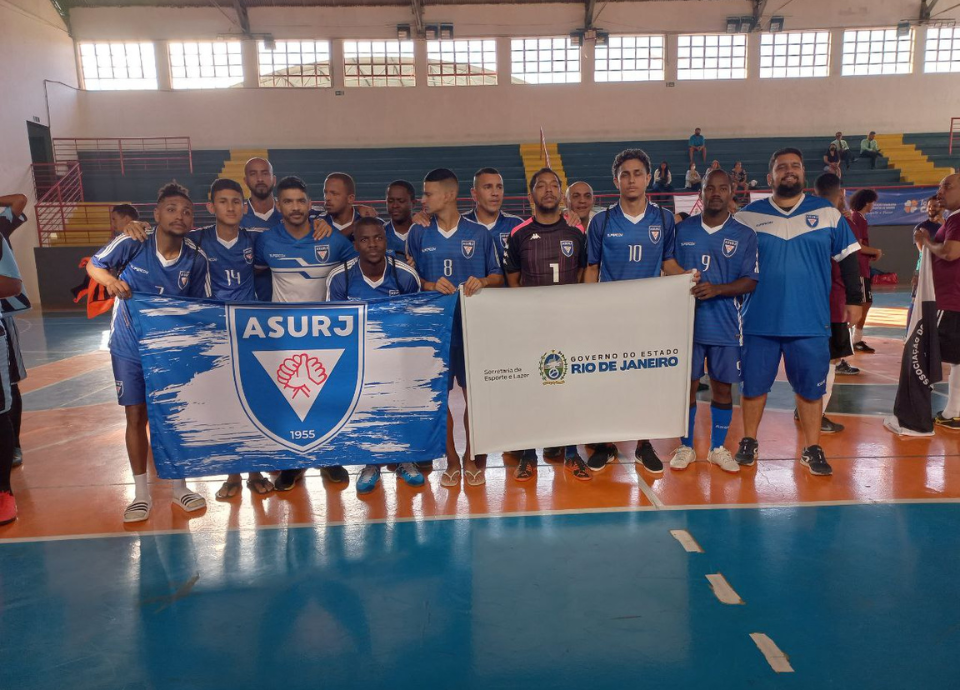 Descrição da imagem: foto dos surdoatletas da ASURJ/RJ. Eles estão perfilados e seguram a bandeira da associação. Fim da descrição.