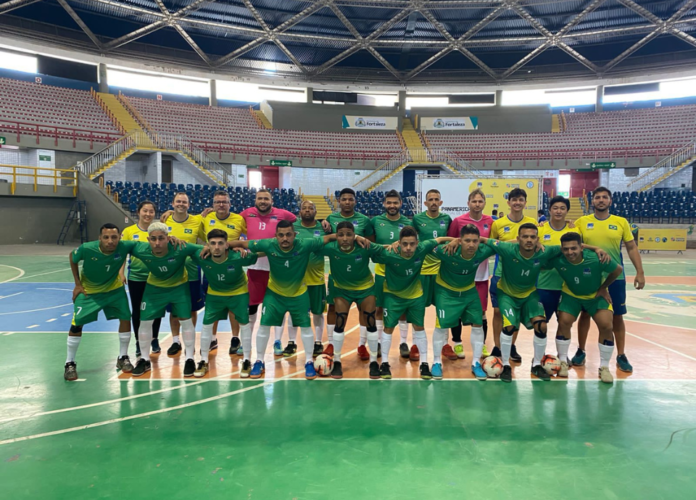 Descrição da imagem: foto dos surdoatletas da Seleção Brasileira de Futsal de Surdos. Eles estão perfilados na quadra. Fim da descrição.