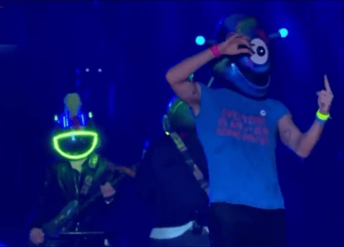 Descrição da imagem: foto do vocalista da banca Coldplay sinalizando na língua de sinais uma música durante o show. Fim da descrição.