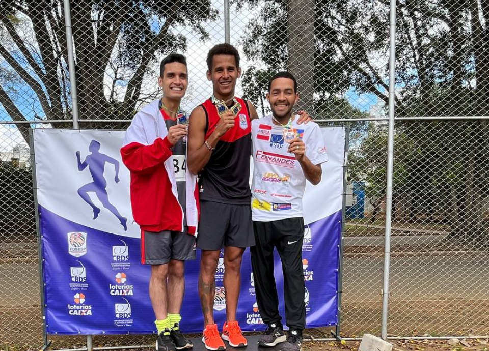 Descrição da imagem: foto dos atletas de atletismo no pódio. Fim da descrição.