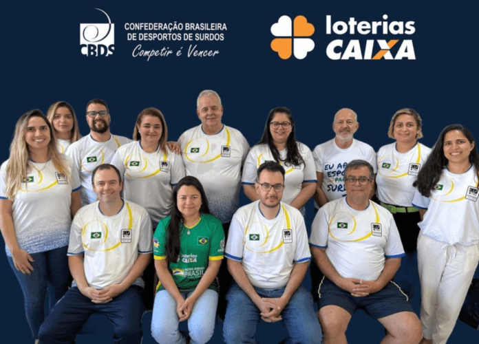 Descrição da imagem: foto da equipe da CBDS. A imagem tem fundo azul escuro. Na parte superior estão os logos da CBDS e das Loterias Caixa. Abaixo estão os integrantes da equipe, perfilados, sendo que 9 pessoas estão em pé e 4 estão sentadas. Fim da descrição.