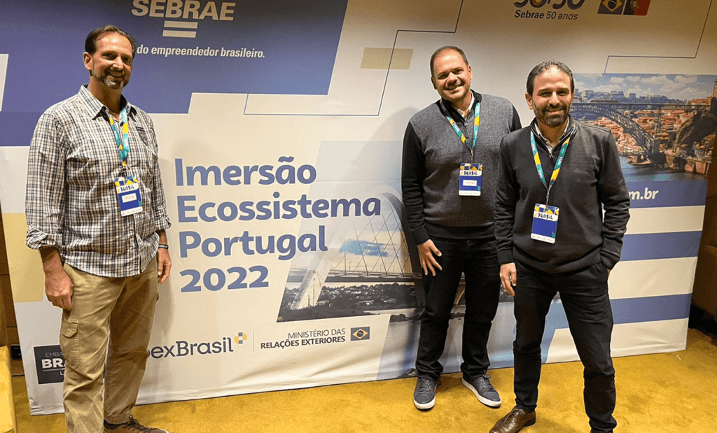 Descrição da foto: foto dos representantes da EqualWeb Brasil no evento. Eles estão ao lado de um painel de divulgação do evento. Fim da descrição.