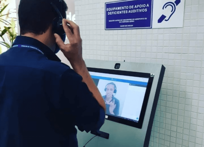 Descrição da imagem: foto de um homem usando o totem de atendimento em Libras. Fim da descrição.