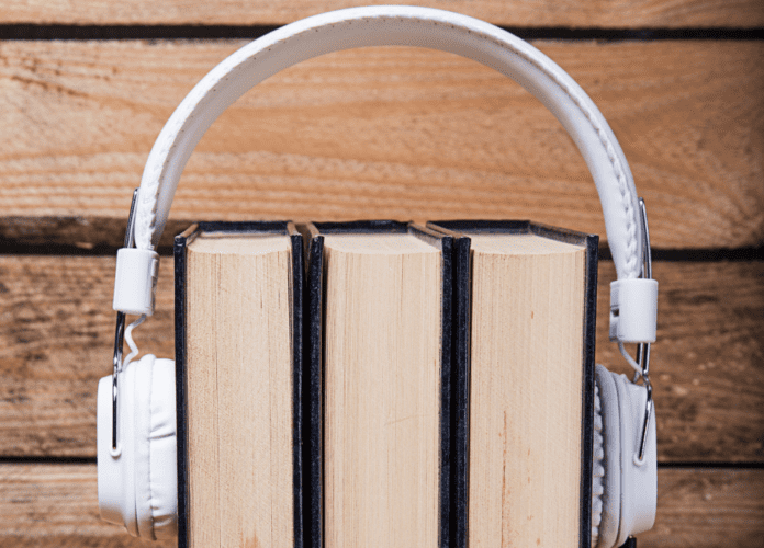 Descrição da imagem: foto de um fone de ouvidos envolvendo três livros.