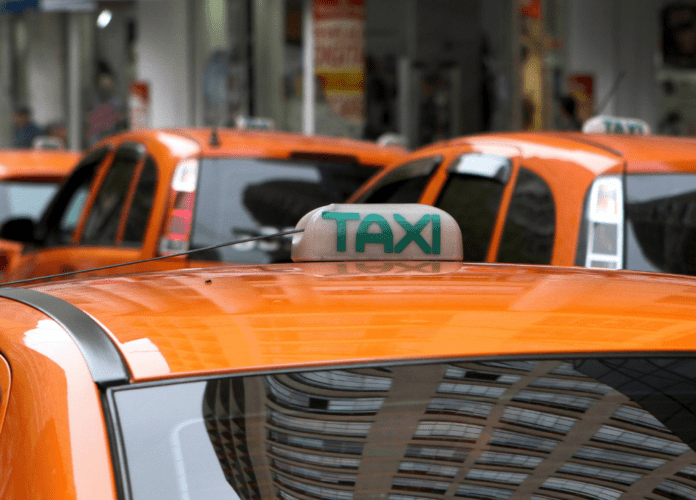 Descrição da imagem: Foto de alguns táxis estacionados na rua. Os carros são amarelo. Fim da descrição.