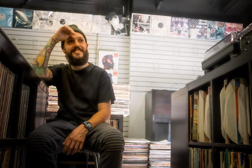 #descricaodaimagem foto do DJ Robbie Wilde. Ele é um homem branco com barba. Robbie usa uma camiseta preta e calça cinza. Fim da descrição.