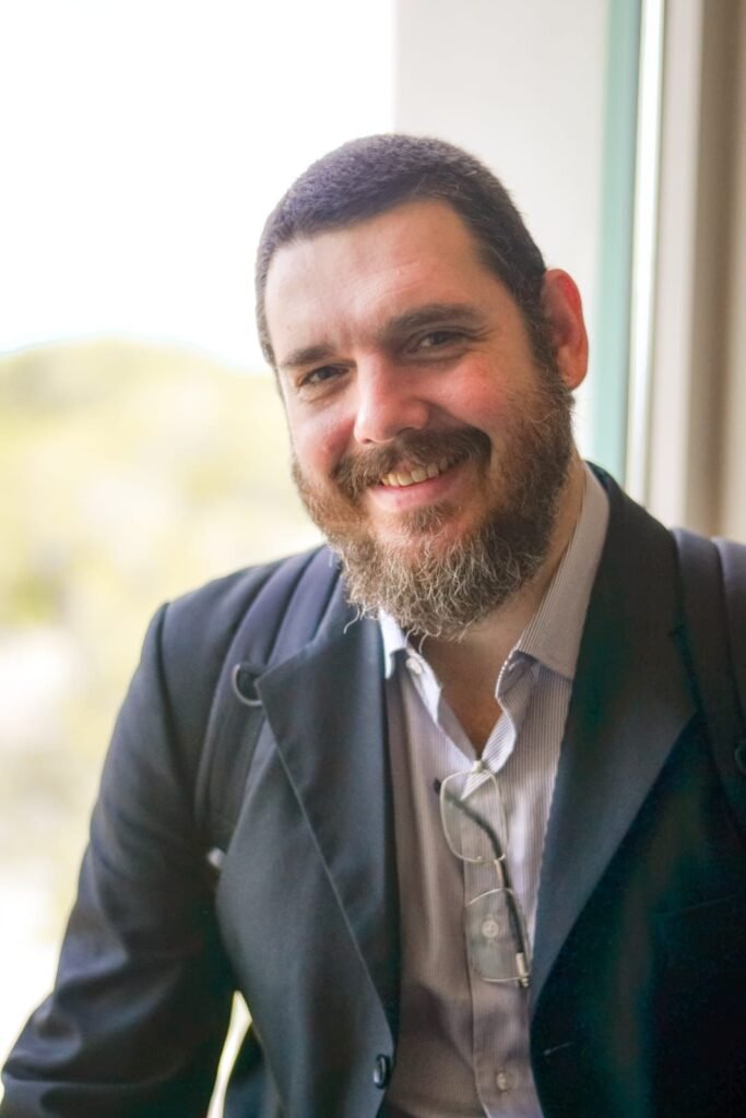 #descricaodaimagem #pratodosverem foto do doutor Rafael. Ele é um homem branco de cabelos e barba castanhos. Fim da descrição.