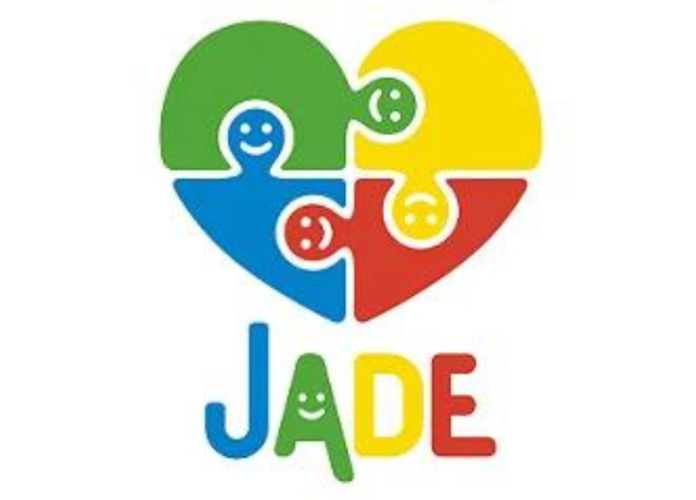 #descricaodaimagem #pratodosverem imagem do logo Jade Autism formado por um coração formado por quatro peças de quebra-cabeça nas cores verde, amarelo, vermelho e azul. Abaixo está escrito Jade.