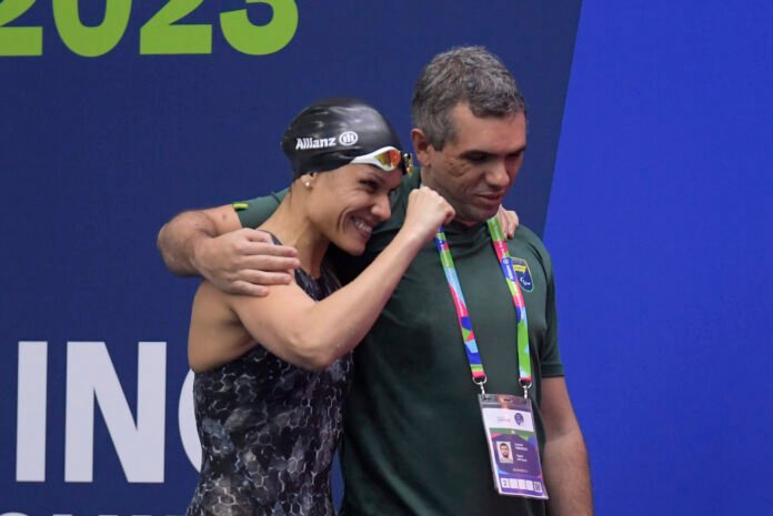 #descricaodaimagem #pratodosverem foto da paratleta Carol Santiago durante comemoração do recorde mundial. Ela está ao lado do seu técnico.