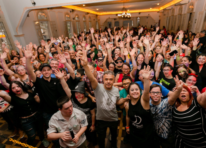 #descricaodaimagem #pratodosverem foto dos participantes de uma festa do Instituto UniDown. Vários jovens com deficiência reunidos, posam para a foto.