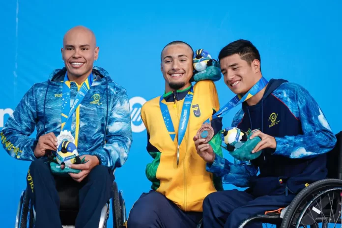 #descriçãodaimagem #pratodosverem foto do paratleta Samuel de Oliveira no pódio. Samuel está no centro, com sua medalha de ouro. Ao seu lado estão os paratletas que conquistaram medalhas de prata e bronze.