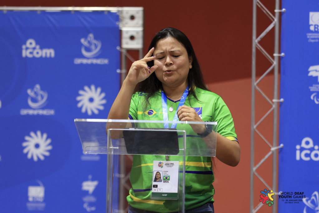#descriçãodaimagem #pratodosverem foto de Diana Kyosen durante discurso. Ela é uma mulher com traços orientais, tem cabelos castanhos, lisos e compridos.