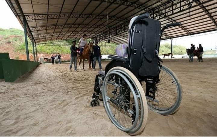 #descriçãodaimagem #pratodosverem foto de uma cadeira de rodas no setting terapêutico durante um atendimento de equoterapia.