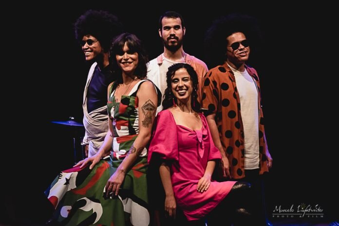 #descriçãodaimagem #pratodosverem foto de Sara Bentes com a banda.
