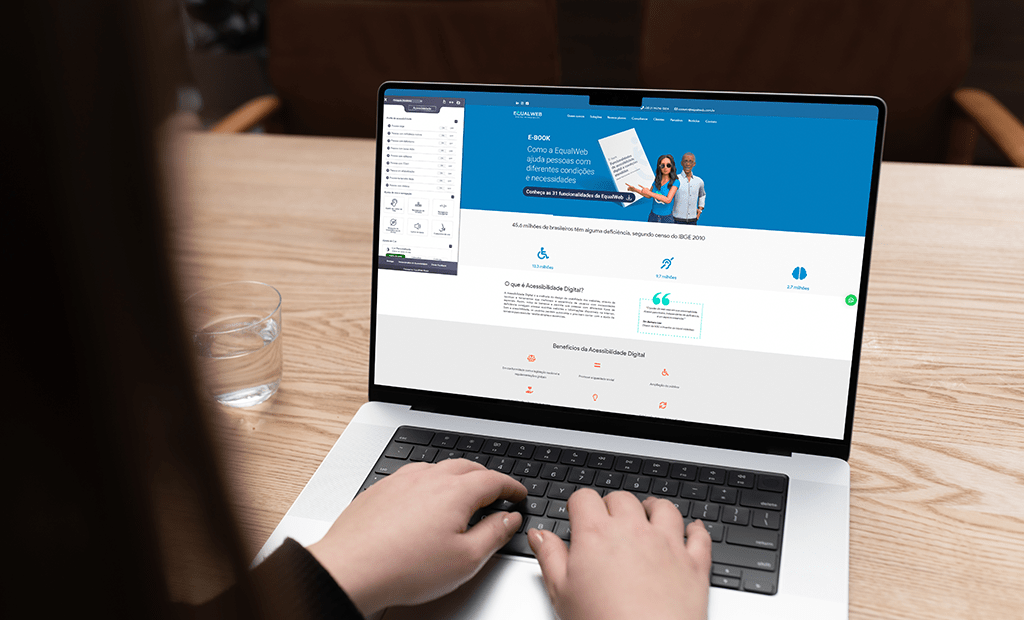 #descriçãodaimagem #pratodosverem foto de uma tela de notebook aberta com o site da Equalweb em primeira página. Na imagem também aparece uma mão digitando no teclado do notebook.