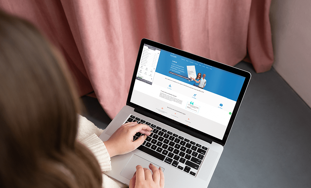 #descriçãodaimagem #pratodosverem foto de uma mulher de costas que está usando um computador, que está no site da EqualWeb.