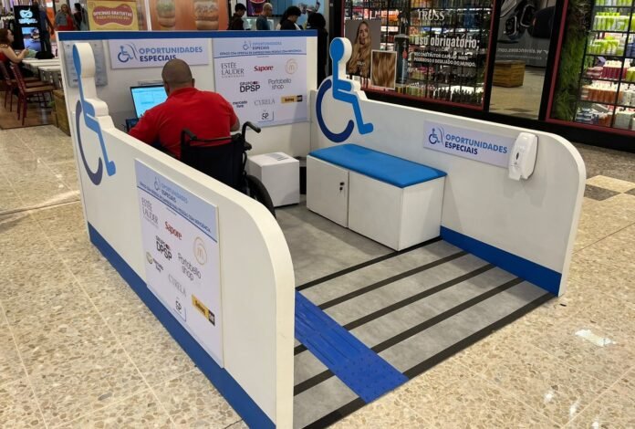 #descriçãodaimagem #pratodosverem foto do estande do Oportunidades Especiais instalado no corredor do shopping. Um homem, cadeirante, está no local.
