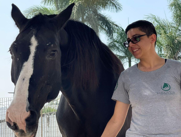 #descriçãodaimagem #pratodosverem foto de uma profissional de equoterapia ao lado de um cavalo.