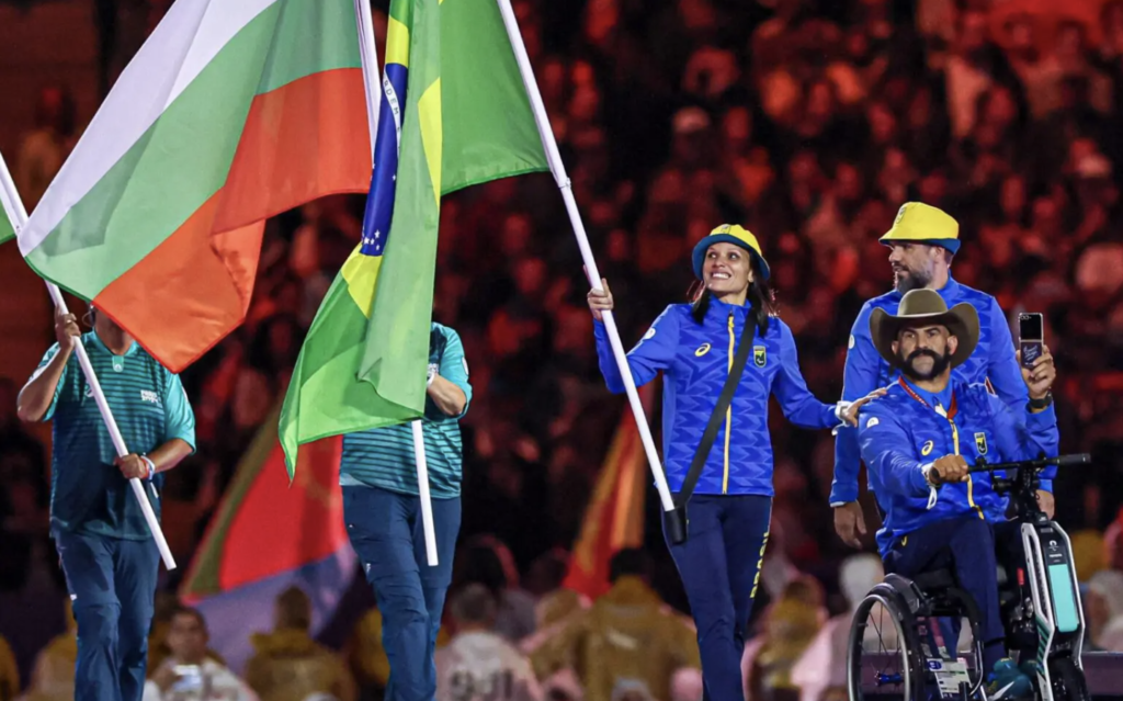 #descriçãodaimagem #pratodosverem os paratletas brasileiros Carol Santiago e Fernando Rufino durante o desfile com a bandeira do Brasil na cerimônia de encerramento dos Jogos Paralímpicos de Paris 2024.