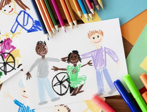 #descriçãodaimagem #pratodosverem foto de um desenho entre vários lápis de cor e papeis coloridos. No desenho está a representação de uma família, com uma criança cadeirante.